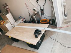 a table with some tools on top of it in a room filled with boxes and other items