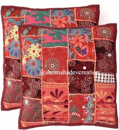 two red pillows with colorful patchwork designs on them, one in the shape of a flower