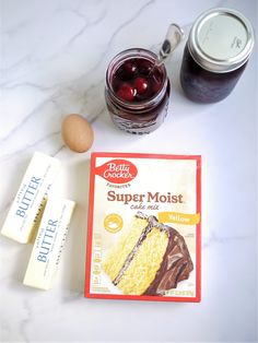 ingredients to make a cake sitting on top of a white marble counter next to an egg