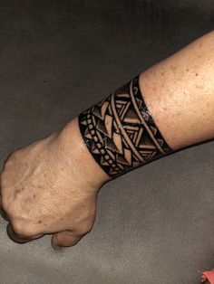 a man's arm with a tattoo on it and his hand holding the wrist