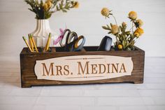 a wooden sign that says mrs medina with scissors and pencils in the holder