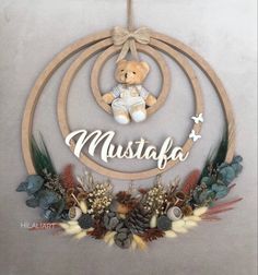 a teddy bear is hanging on a circular wall decoration with the word mustafa