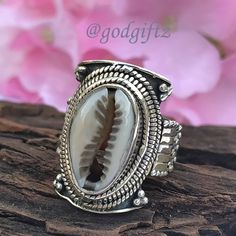 This stunning Cowrie Shell Gemstone Ring is made of polished, textured, and oxidized sterling silver with a handcrafted sterling silver ring setting. The ring has a beautiful and unique design with a high polish that gives the ring a luxe look. This friendship Gift is perfect for everyday wear and is sure to be a conversation starter. Metal : 925 Sterling Silver Weight (Gms) : 9 Gms Approx Style : Cocktail Ring Size :  All Sizes Healing Properties : ------------------------------------------------------------------------------------ The cowrie shell has many uses and meanings. ... Spiritually, according to African legend, if you are attracted to cowrie shells you could be family to an Ocean Spirit of wealth and earth. It also represents Goddess protection which is very powerful and connect Bohemian Engraved Toe Ring, Bohemian Carved Sterling Silver Jewelry, Handmade Bohemian Ring For Anniversary, Bohemian Handmade Rings For Anniversary, Bohemian Engraved Rings As Gift, Bohemian Engraved Open Ring, Handmade Silver Bohemian Rings, Handmade Bohemian Silver Rings, Bohemian Rings With Oxidized Finish For Anniversary