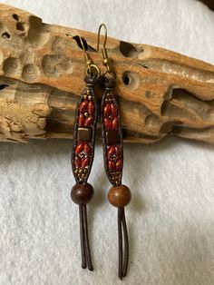 "These long hanging Boho Style earrings are made with Bronze Luster Opaque Red SuperDuo Beads, along with Czech Glass Deep Bronze Tile bead. They have been accented with Seed Beads. I have also added a large wooden bead, all which has been beaded onto brown leather. There is an antique brass tone french earwire for ease of wearing. These earrings measure just about 3-5/8\" inches long, which includes the attached earwire. See picture. They are about 3/8\" inches wide at the beaded portion, and the wooden bead, is just about 1/2\" inch wide. These are very lightweight, and move freely. Free shipping in the US.  Thanks so much for looking!" Adjustable Wooden Beaded Earrings As Gift, Adjustable Brown Earrings With Colorful Beads, Adjustable Brown Beaded Earrings With Large Beads, Adjustable Large Beads Drop Earrings, Adjustable Large Beaded Drop Earrings, Gift Wooden Beaded Earrings, Artisan Red Beaded Earrings With Dangling Beads, Brown Large Beaded Dangle Earrings, Adjustable Festival Earrings With Wooden Beads