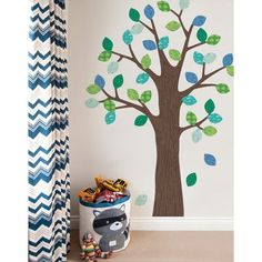 a child's room with a tree painted on the wall and toys under it