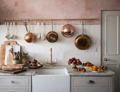 a kitchen with pots and pans hanging on the wall next to an open stove