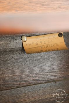 a piece of paper that has been taped to the side of a wooden wall with writing on it