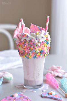 a cup filled with lots of sprinkles on top of a white table