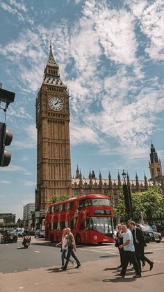 the big ben clock tower towering over the city of london with pedestrians crossing in front