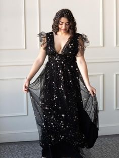 The Starry Eyed Sequin Star Mesh Maxi Dress is a Confête favorite. Starry Eyed features an a-lined silhouette, deep v-neck, glitter stars and a slight ruffle cap sleeve. Fully lined. Hidden back zipper enclosure. 100% poly. Hand wash cold. Comes in black and gold. Pictured in S and L. Celestial Formal Dress, Moon Themed Wedding Dress, Celestial Ball Gown, Elven Dresses, Vestidos Curvy, Moon Wedding Theme, Starfall Ball, Bridesmaids Styles, Glitter Maxi Dress