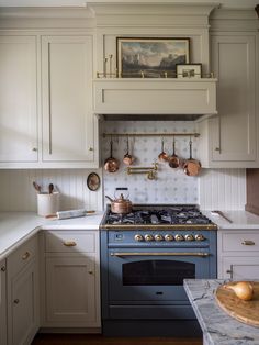 a kitchen with white cabinets and blue stove