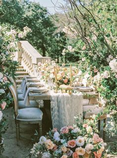 the table is set with many flowers and place settings for four people to sit at