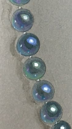 a row of blue glass beads sitting on top of a floor