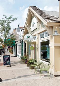 an outside view of a restaurant with tables and chairs on the sidewalk in front of it