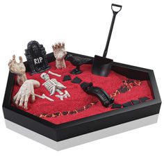 a halloween sand tray with fake skeletons and tombstones