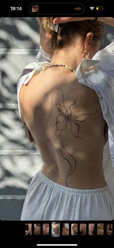 the back of a woman's body with tattoos on it