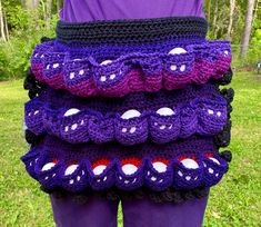 a person wearing purple pants with crocheted designs on them