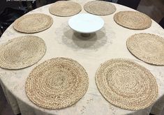 a table topped with lots of placemats on top of a white table cloth