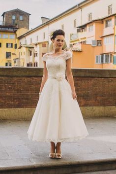 a woman in a white dress standing on some steps