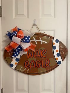 a football shaped door hanger with the words wake eagle on it and a polka dot bow