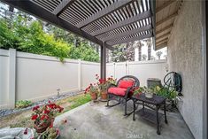 an outdoor patio with chairs and potted plants