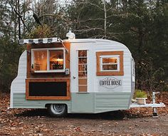 an old camper is parked in the woods with its door open and windows opened