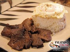 a plate with rice, meat and an egg on it