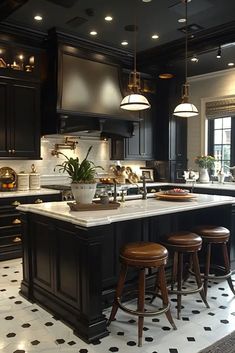 a large kitchen with black cabinets and white counter tops, an island in the center is flanked by stools