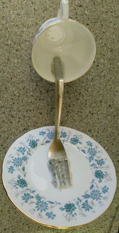 a fork is stuck into a plate with blue flowers