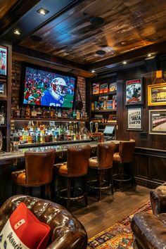 a sports themed bar with leather chairs and televisions on the wall behind it,