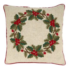 a christmas wreath pillow with holly and red berries on the front, sitting on a white background