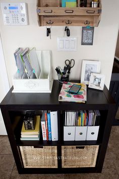 a book shelf with books, binders and other office supplies on top of it