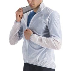 a man in a white jacket and blue tie brushing his hair with a metal brush