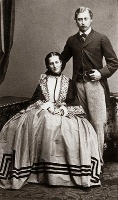 an old photo of a man and woman posing for the camera