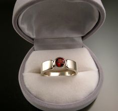 "6mm round brilliant cut red Garnet is bezel-set in sterling silver with 6mm wide by 2mm thick rectangular band. This stone is eye clean and is a very nice beet red color. Weighs roughly 1ct. Specify your ring size in a \"note to seller\" at check-out" Gift Rings With Tension Setting And Thick Band, Thick Band Ring With Tension Setting For Gift, Modern Garnet Jewelry For Anniversary, Classic Ruby Ring With Tension Setting For Gift, Classic Ruby Ring With Tension Setting As Gift, Modern Ruby Ring With Bezel Setting For Anniversary, Gift Jewelry With Tension Setting In Thick Band, Rectangular Tension Setting Ring As A Gift, Modern Garnet Jewelry