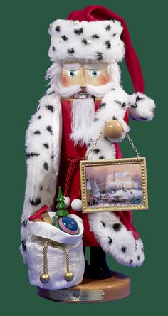 a santa clause figurine holding a painting