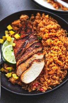 a plate with rice, chicken and pineapples on it next to a fork