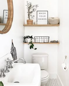 a white bathroom with black and white tile flooring, shelving above the toilet