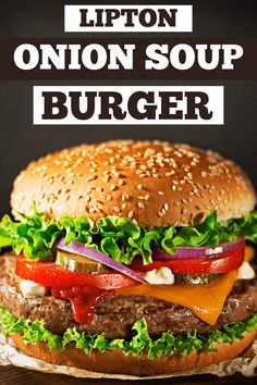 a burger with lettuce, tomato and onion on it in front of a black background