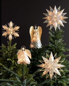 an assortment of christmas decorations on top of a pine tree with angel and star ornaments