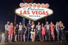 a group of people posing in front of the welcome to fabulous las vegas sign at night