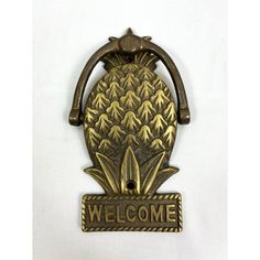 a metal welcome sign with pineapples on it