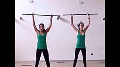 two women in green shirts are doing exercises with barbells on their hands and shoulders