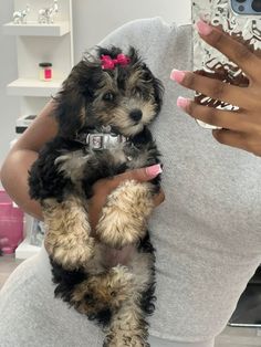 a woman holding a small dog in her arms while taking a selfie with her phone