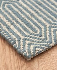 a blue and white rug on top of a wooden floor next to a wood floor