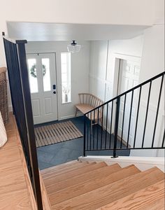 an open door leading to a living room and entryway with wooden steps on either side