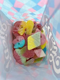 a bag filled with gummy bears sitting on top of a checkered table cloth