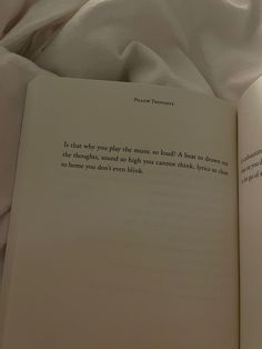 an open book sitting on top of a bed