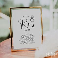 a sign that says put a ring on it sitting on top of a wooden table