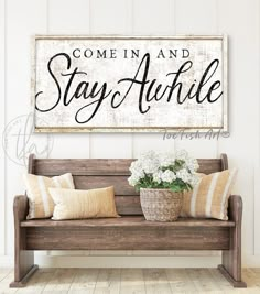 a wooden sign that says, come in and stay awhile on the wall above a bench